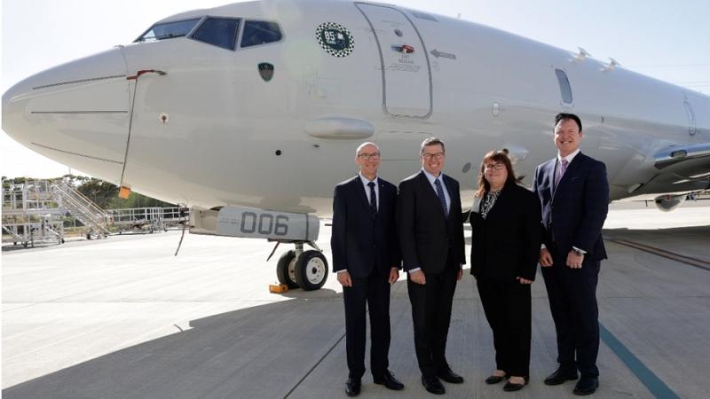   A group photo featuring the Minister for Defence Industry and Capability Delivery alongside the ASCA team, standing in front of the P-8A Poseidon.